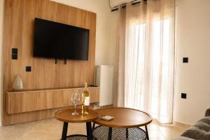 a living room with a table and a tv on a wall at Luminosa Collection - Casa Celeste in Razáta +2 photos