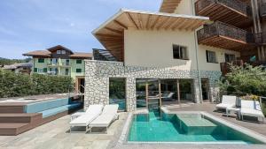a villa with a swimming pool and a house at Blu Hotel Natura & Spa - Adults Only in Folgaria