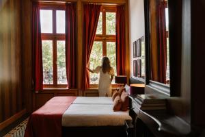 a woman looking out the window of a hotel room at Grand Boutique Hotel-Restaurant Huis Vermeer in Deventer