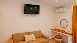 a living room with a couch and a mirror at Hotel Zafira in Skala Rachoniou
