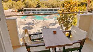 a balcony with a table and chairs and a pool at Hotel Zafira in Skala Rachoniou