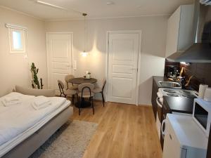 a room with a bed and a kitchen with a table at Metsäniitty in Kempele