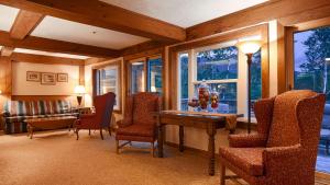 a living room with a table and chairs and windows at Silver Fox Inn in Waterville Valley