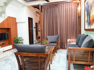 a living room with two couches and a table at The Tree Resort in Malavli