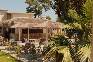 a house with a patio with chairs and umbrellas at Hotel Zafira in Skala Rachoniou