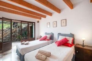 two beds with red pillows in a room at Can Carabá in Illes Balears +24 photos