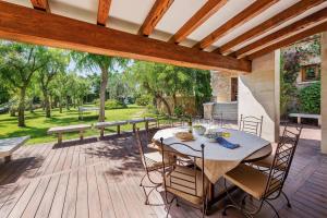 a patio with a table and chairs on a wooden deck at Finca Playa Llenaire - Can Pou in El Port