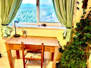 a window with a wooden table and a chair in front of it at בשקט שלך in Mattat