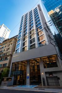 a tall building with many windows in a city at Jamsil Hotel Vene in Seoul