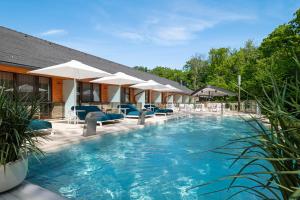 a swimming pool with chairs and umbrellas at Avalon Resort & SPA in Miskolctapolca +56 photos