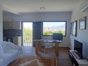 a living room with a desk with a computer on it at Vila Blue River in Orikum