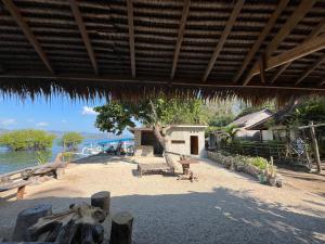 a pavilion with a table and benches on a beach at Lombok eco Lumbung in Gili Gede