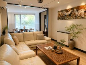 a living room with a white couch and a table at 別荘 1日1組貸切 芦ノ湖徒歩1分 最大16名 BBQ設備レンタルOk 無料駐車場 in Hakone