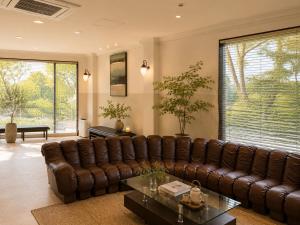 a living room with a brown leather couch at 別荘 1日1組貸切 芦ノ湖徒歩1分 最大16名 BBQ設備レンタルOk 無料駐車場 in Hakone
