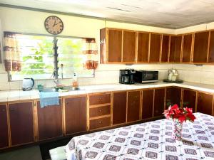 a kitchen with wooden cabinets and a clock on the wall at Melissa cozy corner in Tafuna