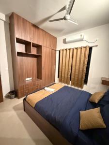 a bedroom with a blue bed and a ceiling fan at coastal coral in Tirupporūr +28 photos