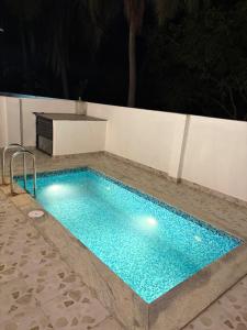 a swimming pool at night with a blue at coastal coral in Tirupporūr