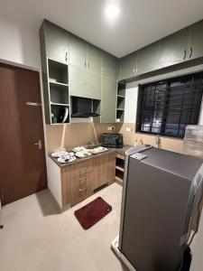 a kitchen with green cabinets and a black refrigerator at coastal coral in Tirupporūr