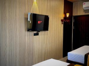 a tv on the wall of a hotel room at Serenity Beach Inn in Pondicherry