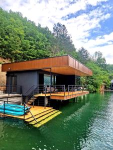 a building on a dock on the water at Perućac Lake Residence in Miličevići