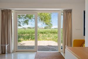 an open door with a view of a field at HollyWad in Holwerd