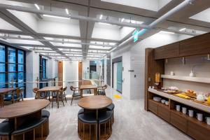 a kitchen and dining room with wooden tables and chairs at Jamsil Hotel Vene in Seoul