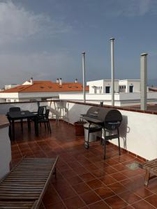 a patio with tables and chairs on a roof at Casa Checa Apartment 3 in El Cotillo