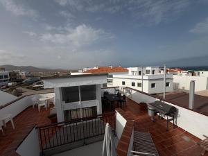 a balcony with tables and chairs on a building at Casa Checa Apartment 3 in El Cotillo