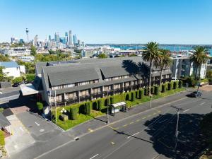 an overhead view of a building with a street and palm trees at Auckland Rose Park Hotel in Auckland