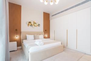 a bedroom with two white beds and a chandelier at La Vie on JBR in Dubai