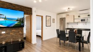 a kitchen and dining room with a tv and a dining table at JVG VILLAS - Villa Joval in Güimar
