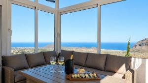 a living room with a couch and a table with wine glasses at JVG VILLAS - Villa Joval in Güimar
