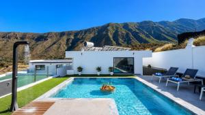 a villa with a swimming pool with mountains in the background at JVG VILLAS - Villa Joval in Güimar +24 photos