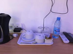 a tray with cups and a bottle of water on a desk at HOTEL GANI in Manjacaze