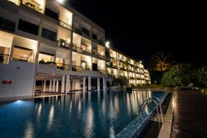 a large building with a swimming pool at night at Citrus Waskaduwa in Kalutara