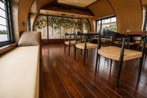 a bar with chairs and tables in a room with windows at Southern Panorama Houseboats in Alleppey