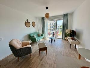 a living room with two chairs and a television at DOMITYS - Les Cerfs-Volants in Berck-sur-Mer