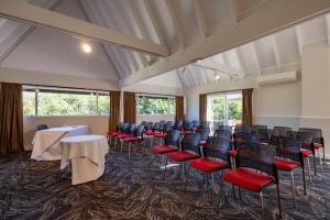 a conference room with chairs and tables and windows at Auckland Rose Park Hotel in Auckland +106 photos