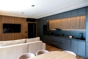 a living room with a couch and a kitchen at Perućac Lake Residence in Miličevići