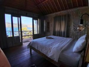 a bedroom with a bed with a view of the water at Lombok eco Lumbung in Gili Gede