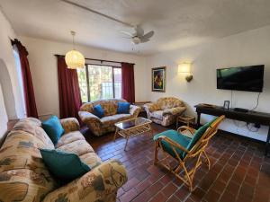 a living room with couches and a flat screen tv at Peter Pan Place in Port Edward