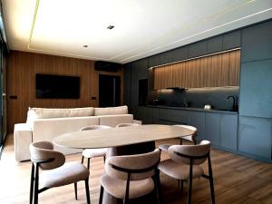 a dining room with a table and chairs and a couch at Perućac Lake Residence in Miličevići
