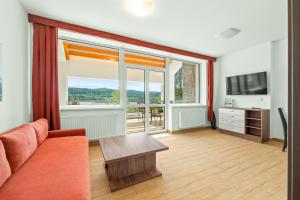 a living room with a couch and a large window at Apartmány Star Lipno - Self Check-in in Lipno nad Vltavou