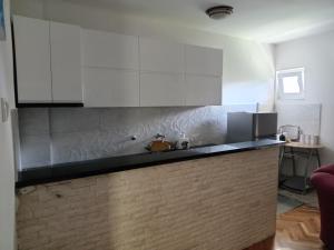 a kitchen with white cabinets and a counter top at Apartman View in Trebinje +3 photos