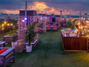 a rooftop bar with a woman sitting at a table at Novotel Madrid Center in Madrid +169 photos