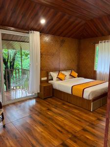 a bedroom with a large bed and a balcony at Cave Valley Wayanad in Ambalavayal +122 photos