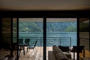 a balcony with a view of a lake and a table and chairs at Perućac Lake Residence in Miličevići +9 photos