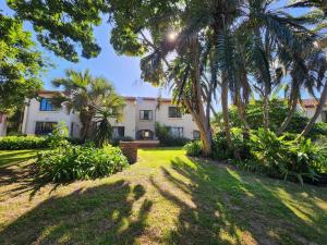 an exterior view of a house with palm trees at Peter Pan Place in Port Edward