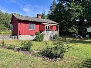a red house with a fence and a yard at KalmarStay in Blomstermåla