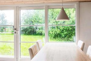 a dining room with a table and a large window at Coastal Hideout Vacation Home in Bøtø By